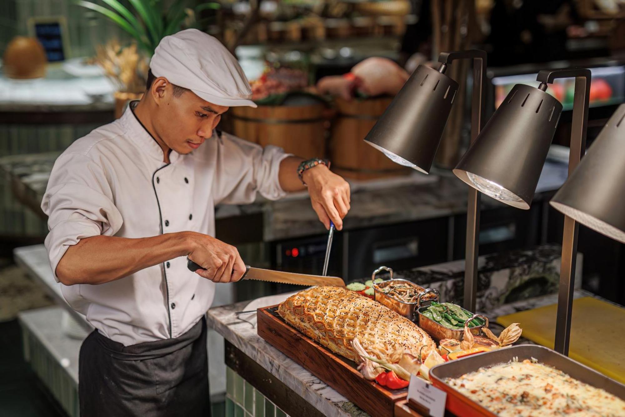 Mai House Saigon Hotel Thành Pho Ho Chí Minh Esterno foto A chef carving a roast